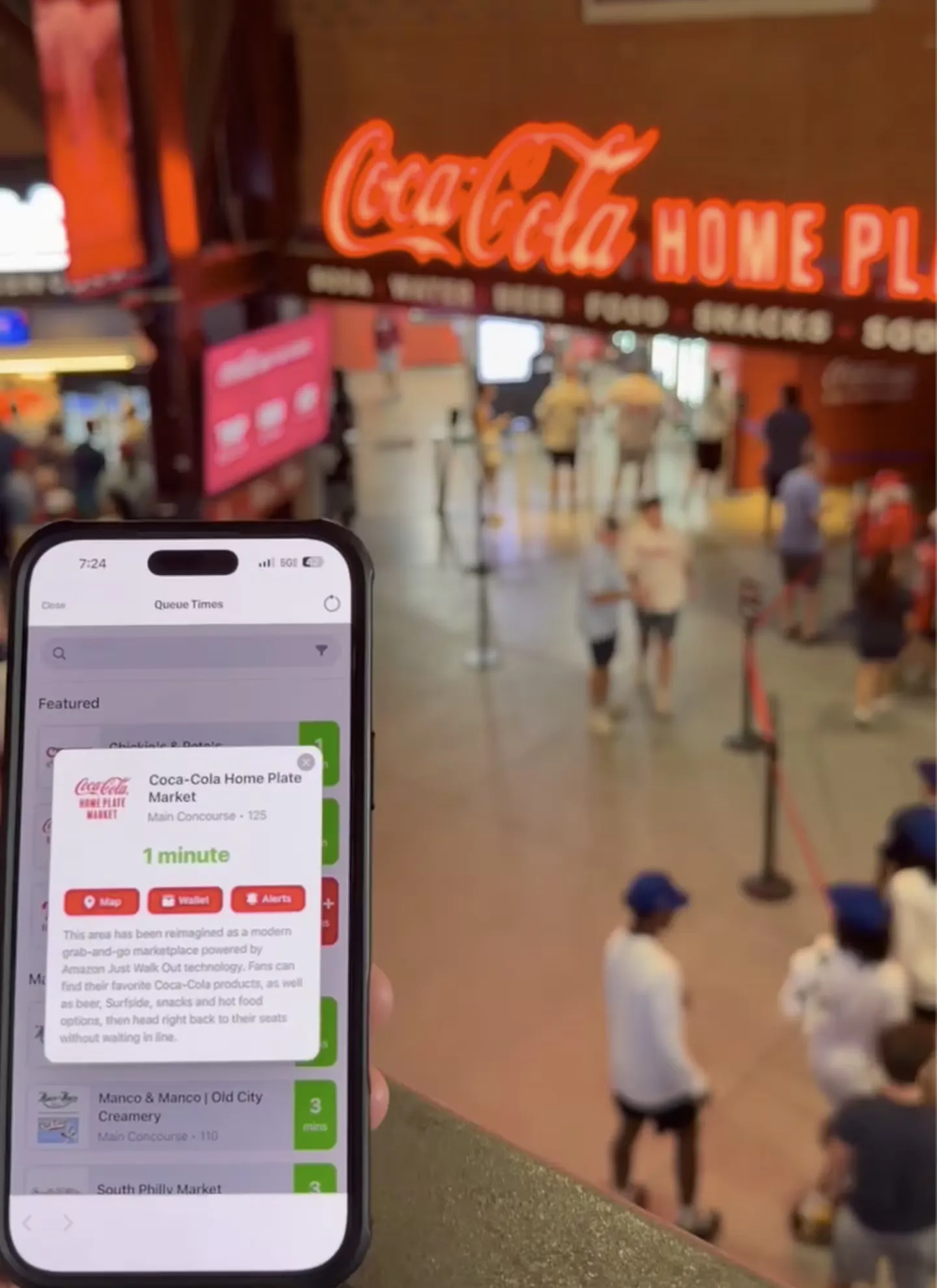 A phone showing a 1-minute queue time for a concession stand, in front of the line at the ballpark